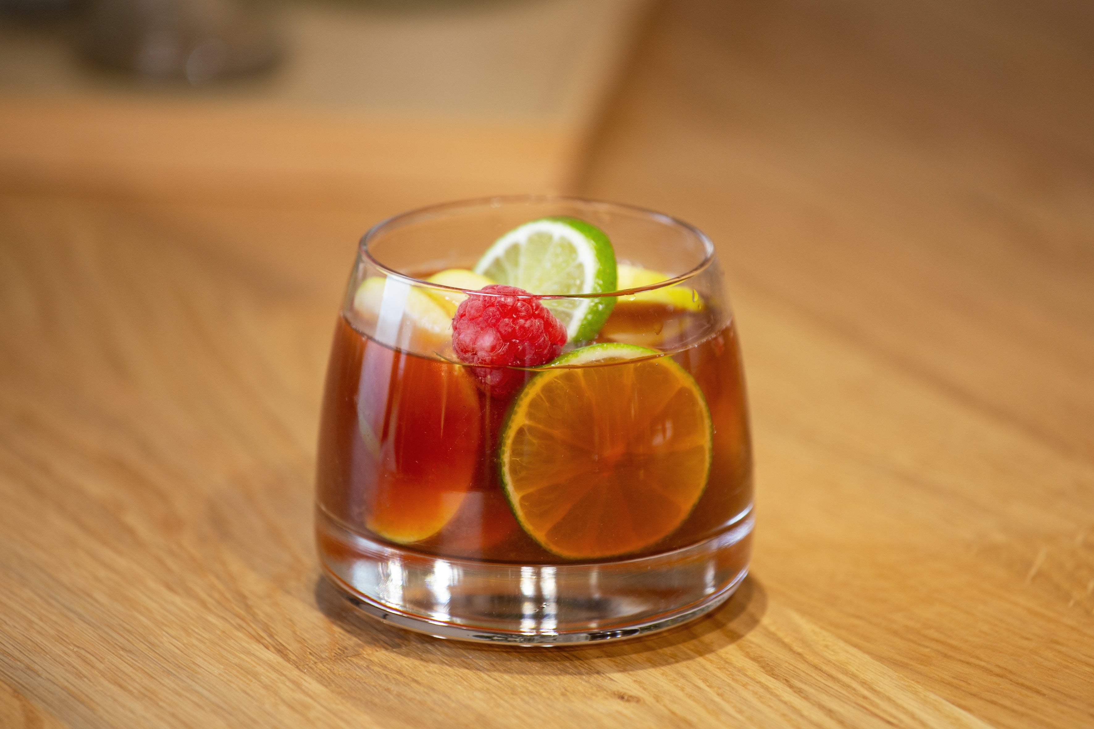 Coffee Sangira: leckerer drink mit limette, apfel und himbeeren garniert