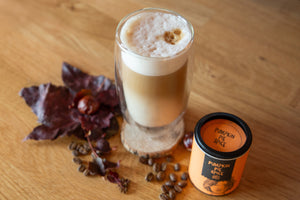 Pumpkin Spice Latte auf Holztisch mit Blätter und Kastanie als Herbstdeko und Pumpkin spice Gewürz von Just spices