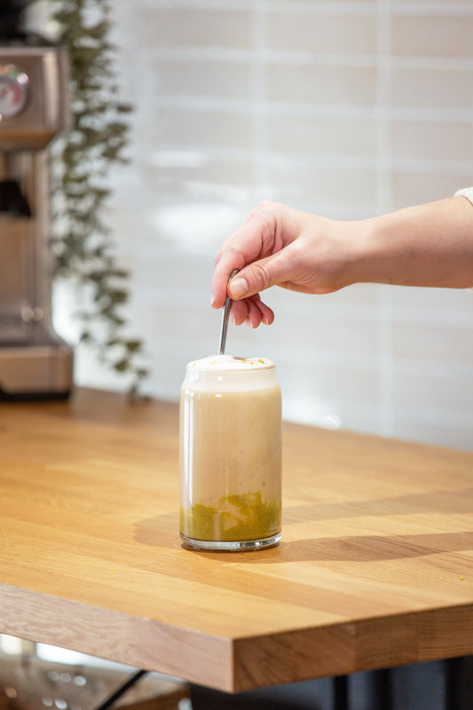 Kaffeerezept: Pistazien-Latte wird von Person umgerührt