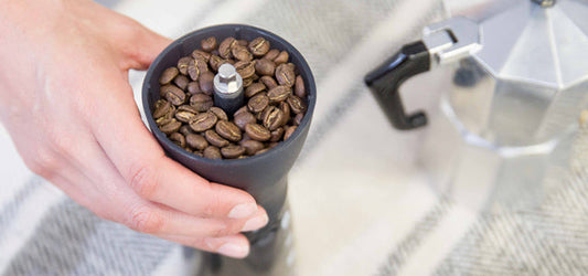 Kaffeezubereitung: Handmühle und Moka Kanne mit Kaffeebohnen